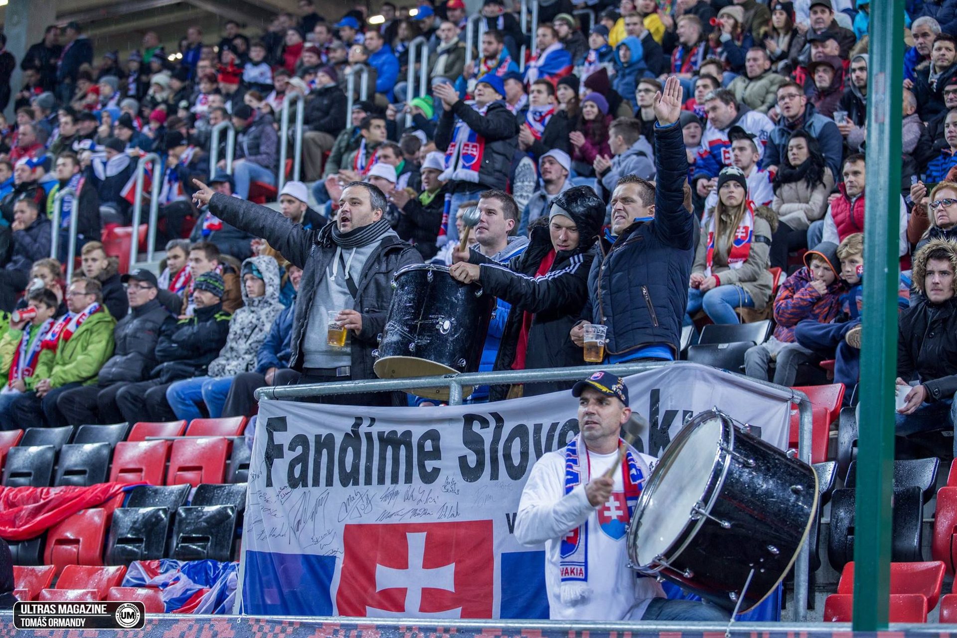 Fanúšikovia na štadióne s bubnami a vlajkami